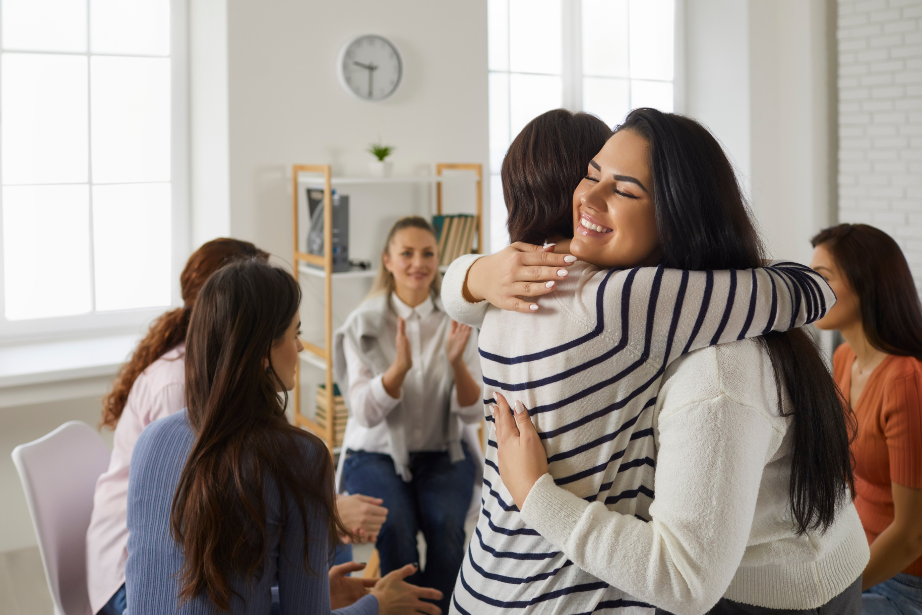Happy Young Women Hugging Each Other in Support Group Meeting or Therapy Session